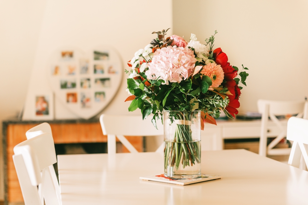 image is of a dining room with spring flowers in a vase