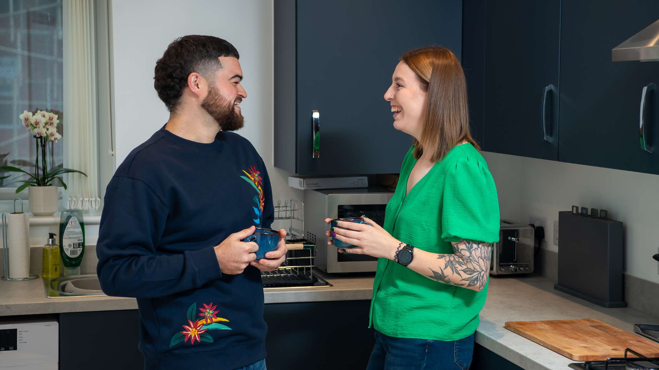 Sam and Sophie having coffee and chatting in their kitchen