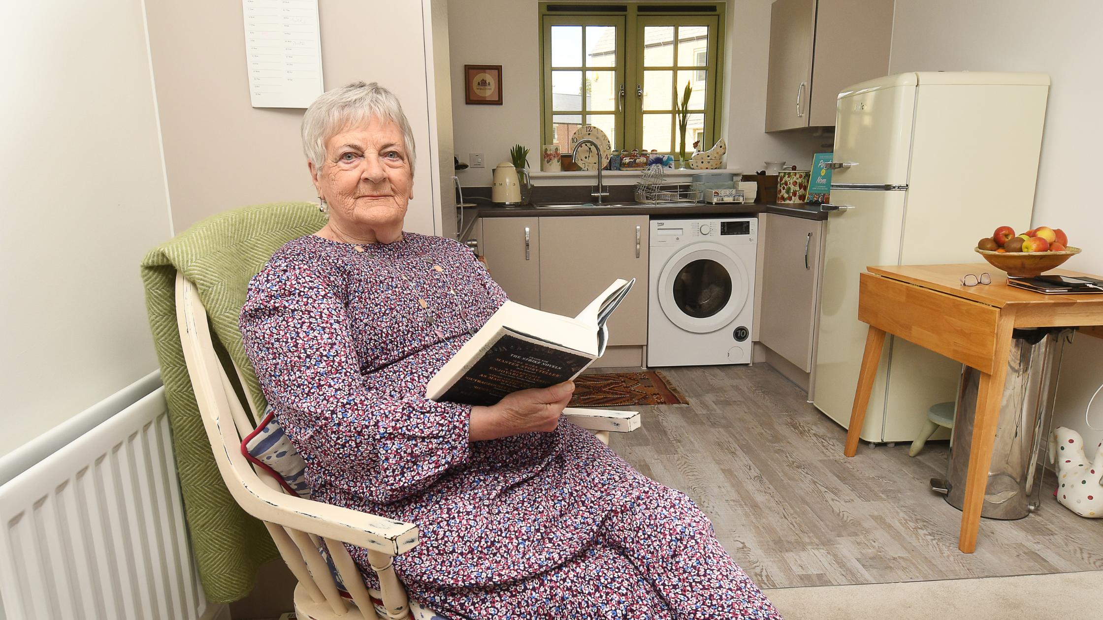 Mary sat reading a book in her lounge
