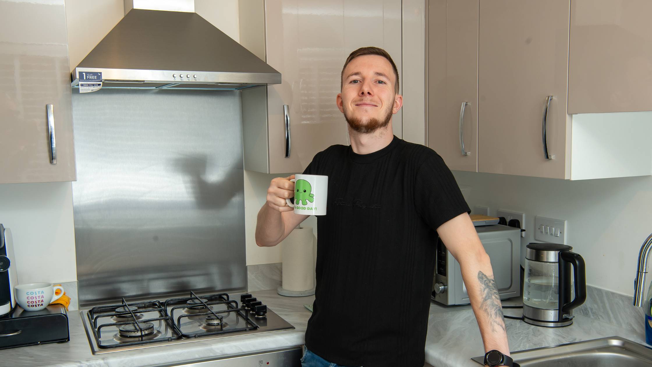 Luke enjoying a coffee in his kitchen