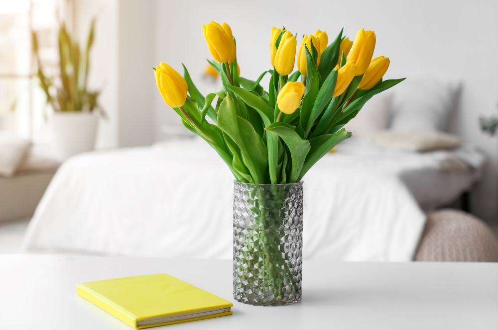 image is of a bedroom with spring flowers in a vase