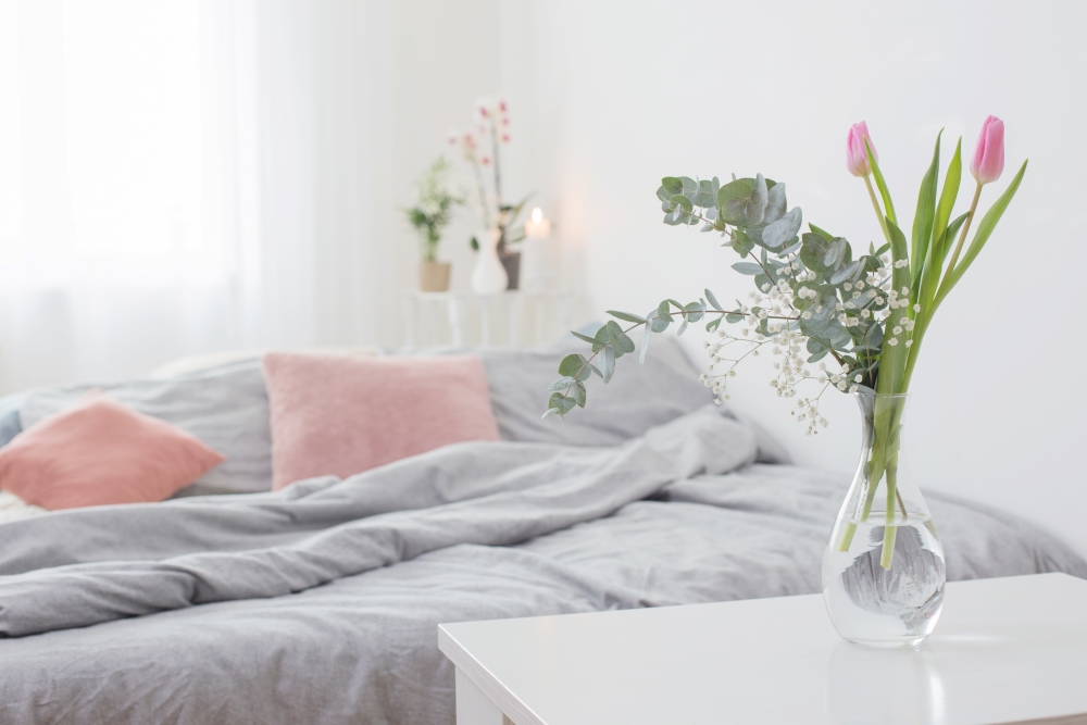 image is of a bedroom with spring flowers in a vase