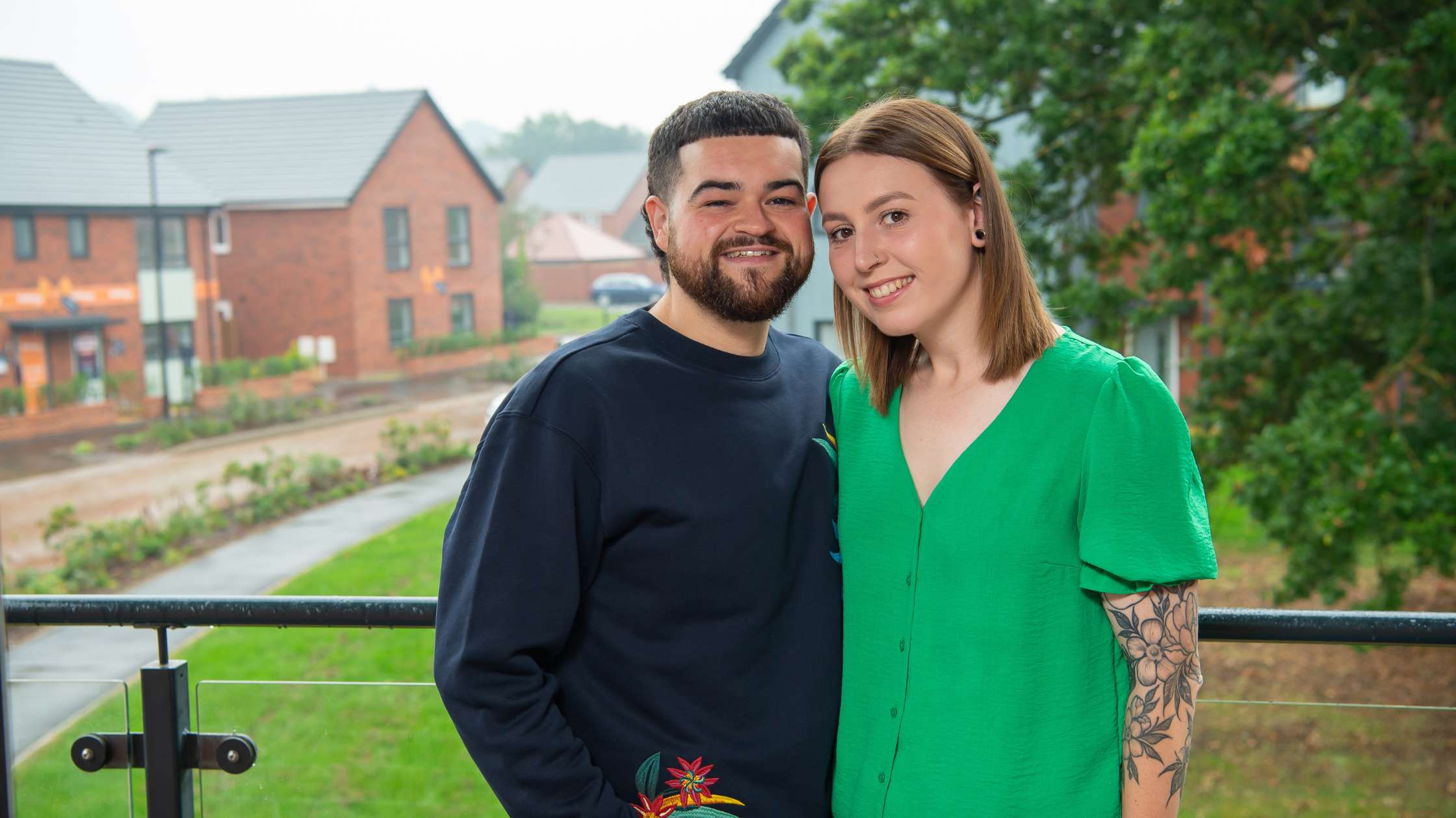 Sam and Sophie standing on their balcony