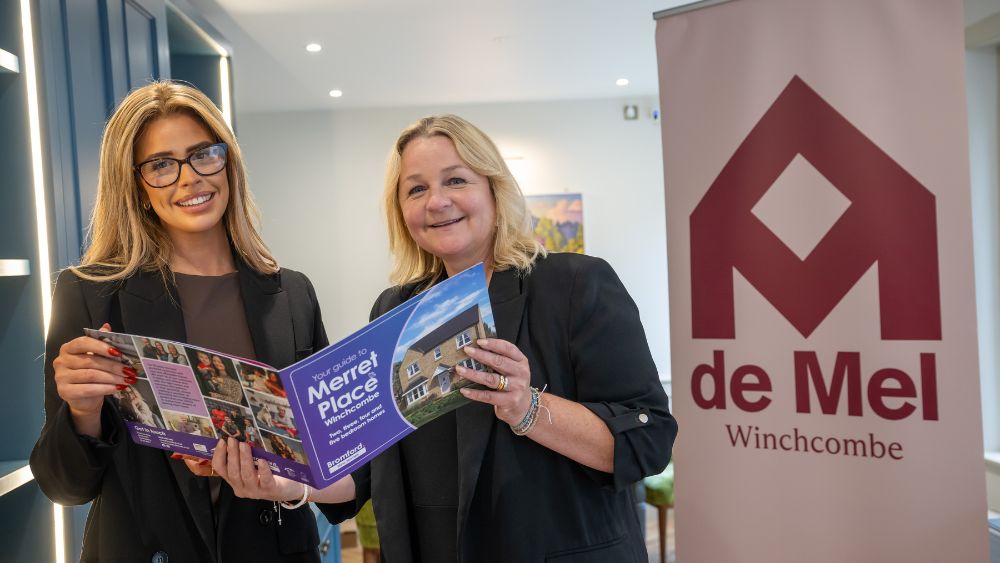 Two people showcasing a Merret Place leaflet