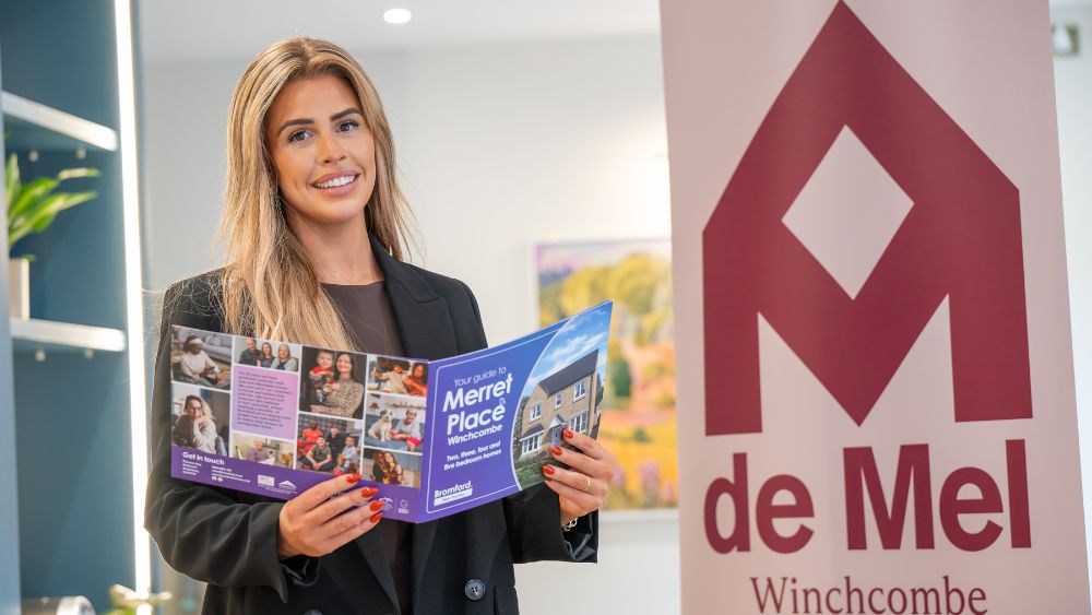 De Mel employee holding a Merret Place brochure.